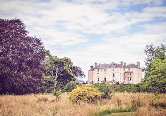 Colstoun House surrounded by grass and trees